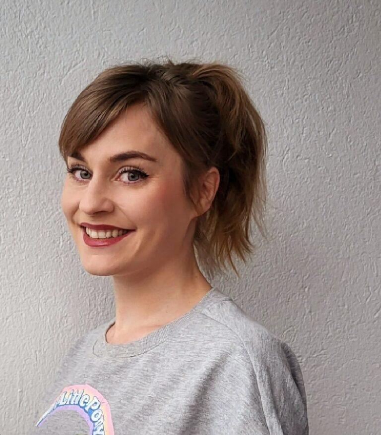 Nainen hymyilee kameralle