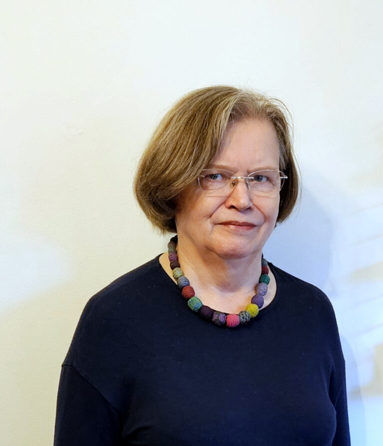 Nainen hymyilee kameralle